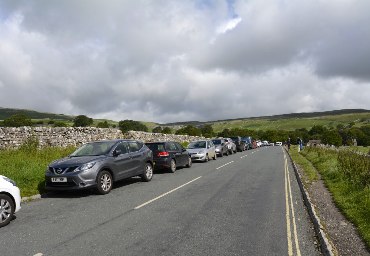 Cars parked on the roadside in Malham, Yorkshire Dales
